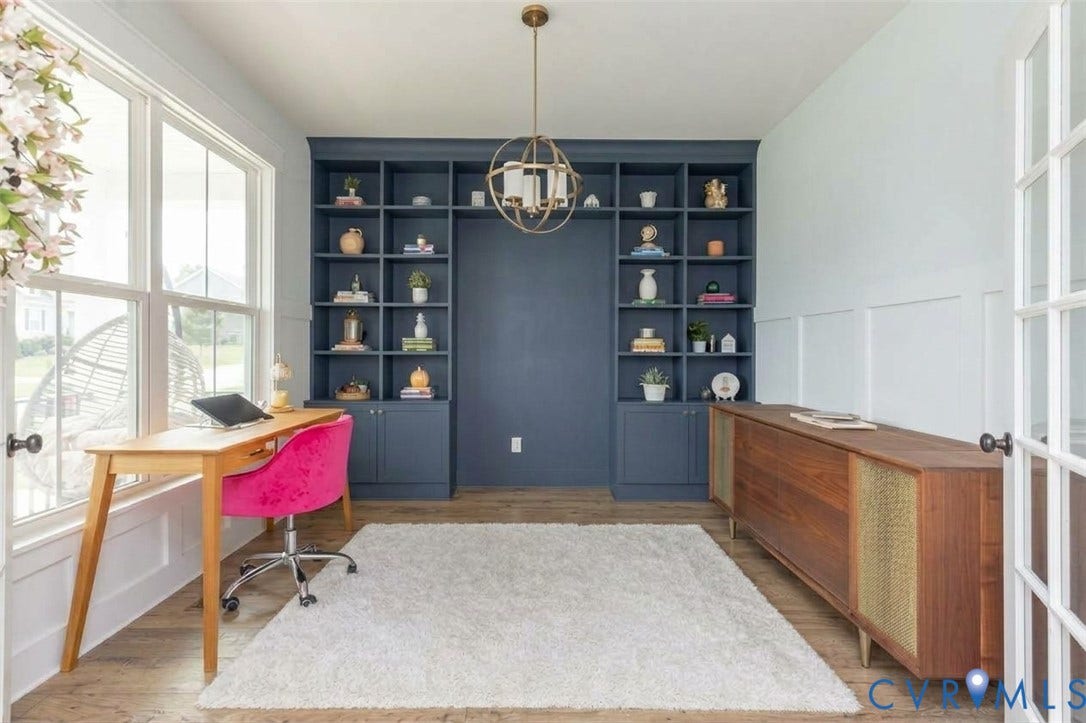 Built-in shelving unit with lower cabinetry, wood-finish flooring, and a decorative chandelier