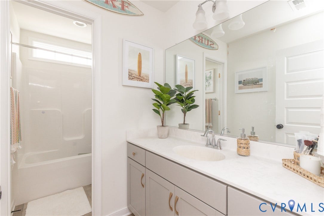 White vanity with dual sinks, chrome fixtures, and a white countertop