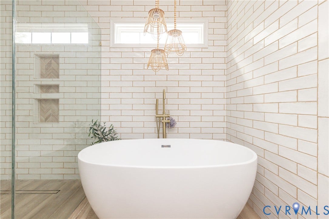 Freestanding oval soaking tub with floor-mounted brass fixture
