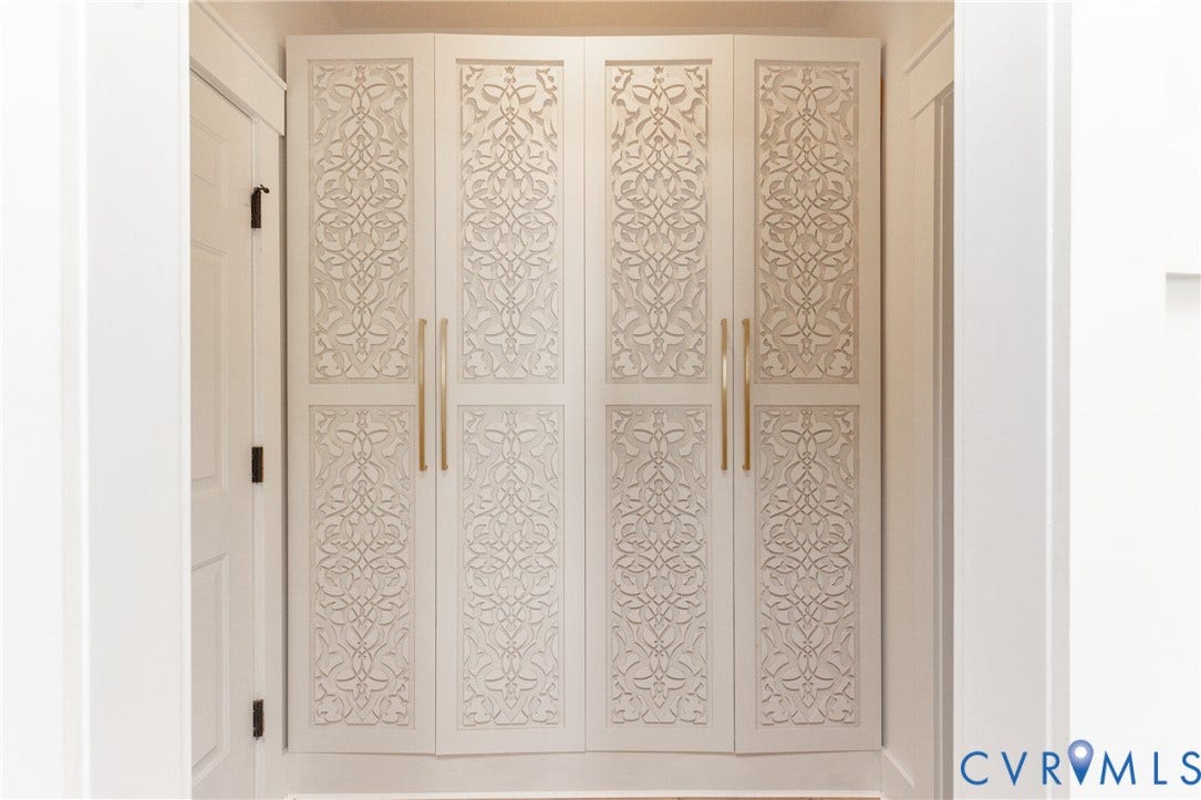 Built-in cabinetry with decorative carved panels and gold-tone hardware