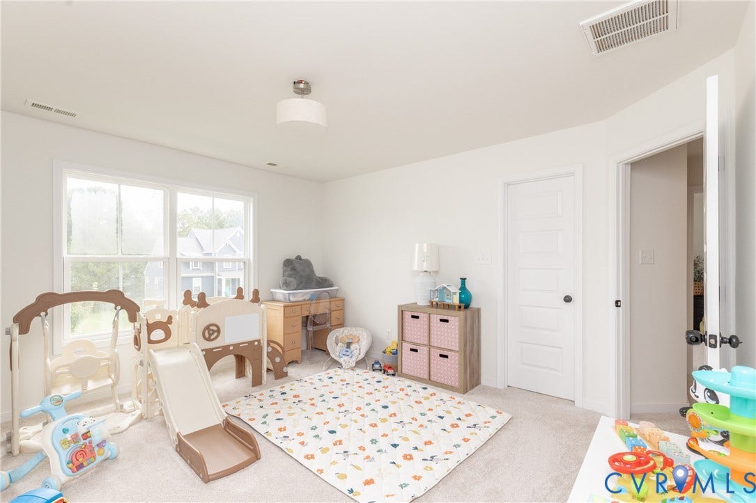 Room featuring light-colored carpeting, white walls, and a multi-pane window