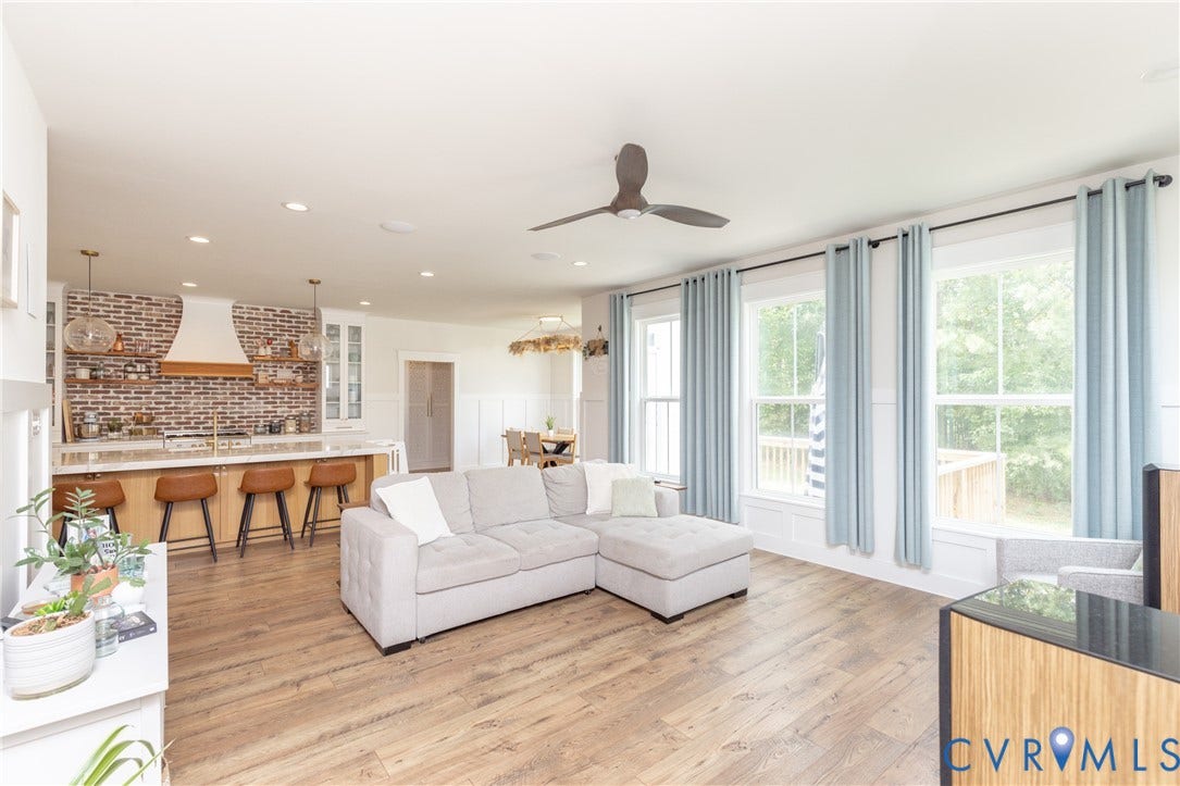 Open-concept living area featuring wood-finish flooring, recessed lighting, and a ceiling fan