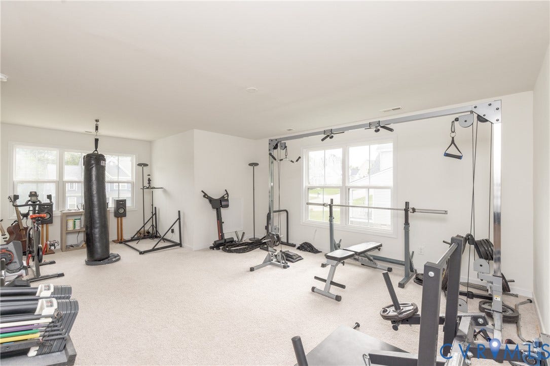 Spacious room featuring carpeting and multiple windows for natural light