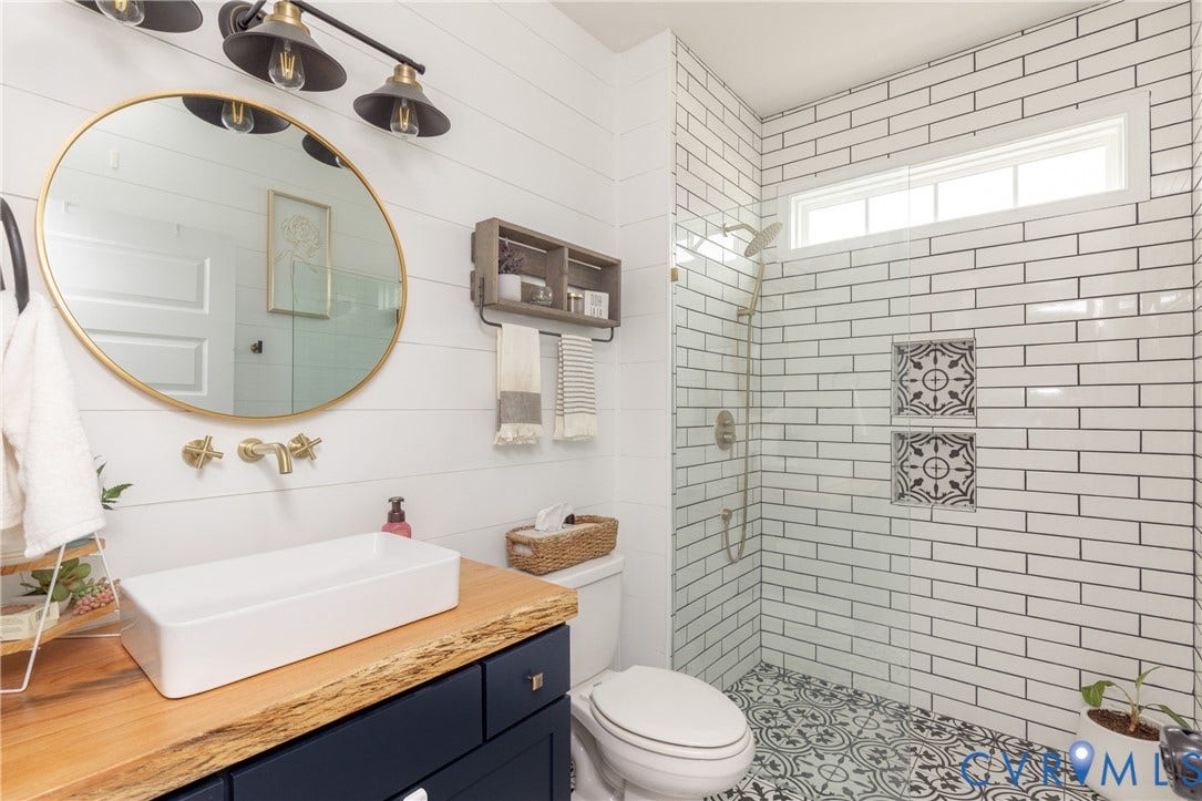 Bathroom featuring a rectangular vessel sink, wood-finish countertop, and dark blue vanity