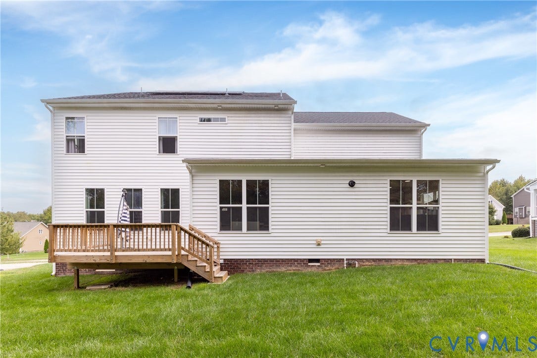 White vinyl siding exterior with an elevated wood deck