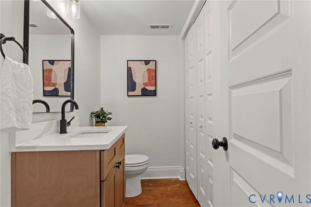 2931 W Leigh Street, Scotts Addition, Richmond, VA 23230 Wood-finish vanity with a white countertop and matte black fixtures
