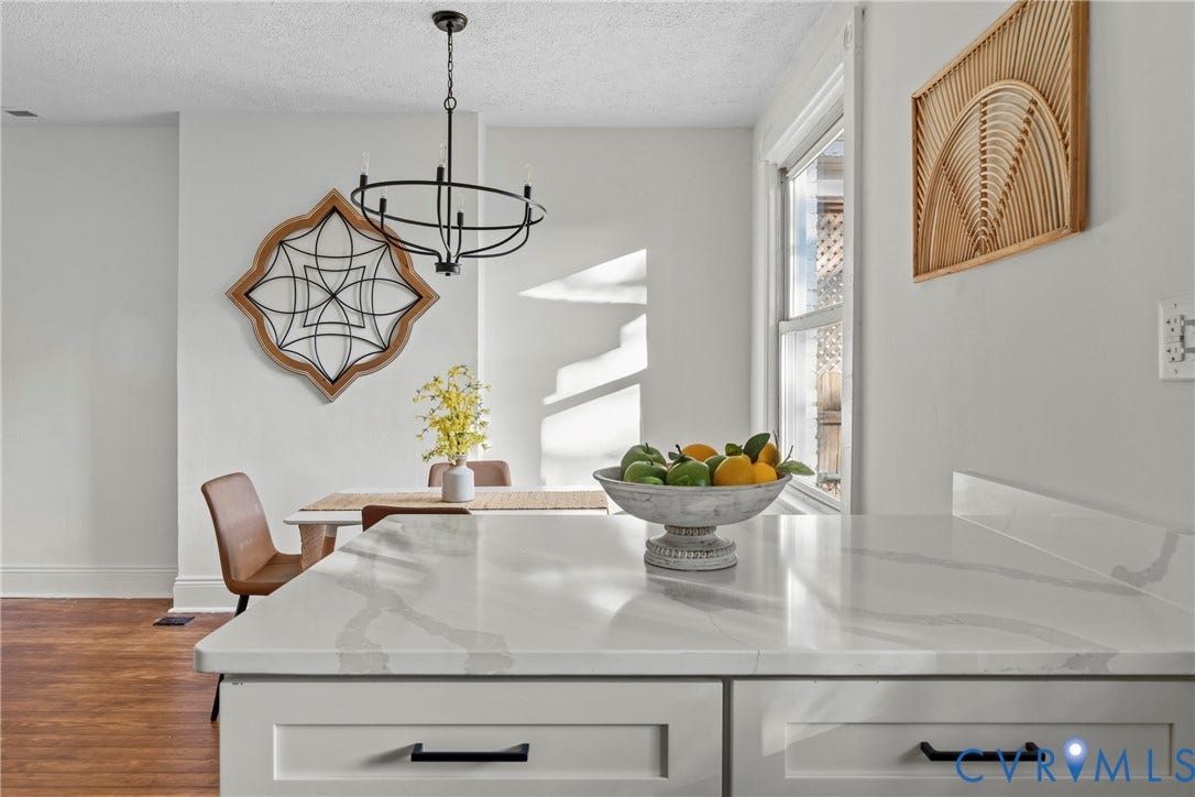 2931 W Leigh Street, Scotts Addition, Richmond, VA 23230 White cabinetry with matte black hardware, white countertops with subtle veining, and wood-finish flooring