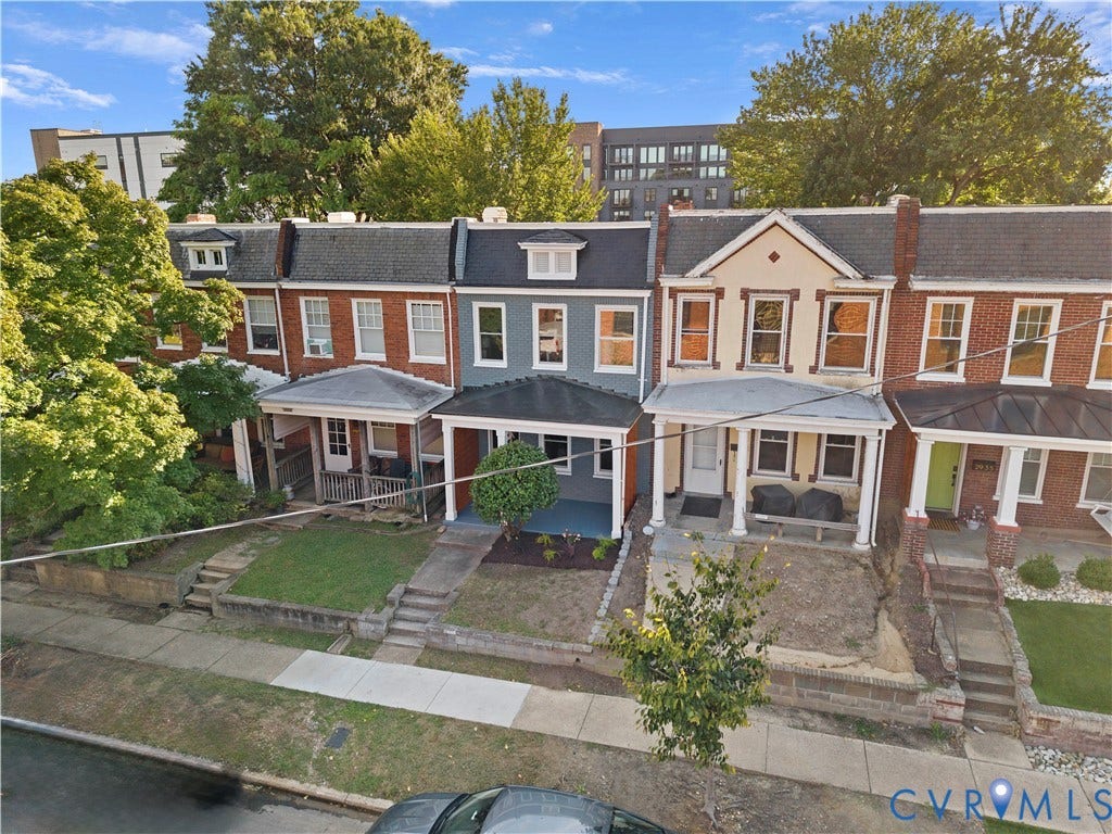 2931 W Leigh Street, Scotts Addition, Richmond, VA 23230 Brick facade with white window trim, covered front porch, and dormer windows