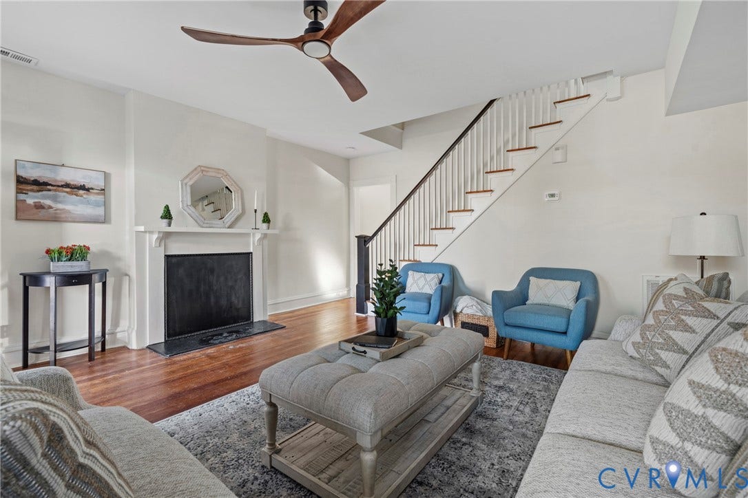 2931 W Leigh Street, Scotts Addition, Richmond, VA 23230 Hardwood-finish flooring throughout, featuring a fireplace with a white mantel, and a staircase with white risers and dark handrail