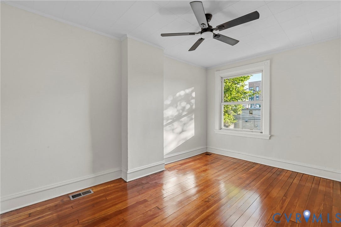 2931 W Leigh Street, Scotts Addition, Richmond, VA 23230 Hardwood flooring, crown molding, double-hung window, and a ceiling fan with light fixture