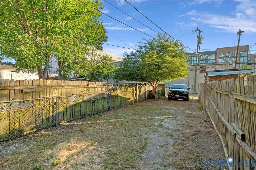 2931 W Leigh Street, Scotts Addition, Richmond, VA 23230 Private backyard space featuring a wood fence, mature tree, and paved drive
