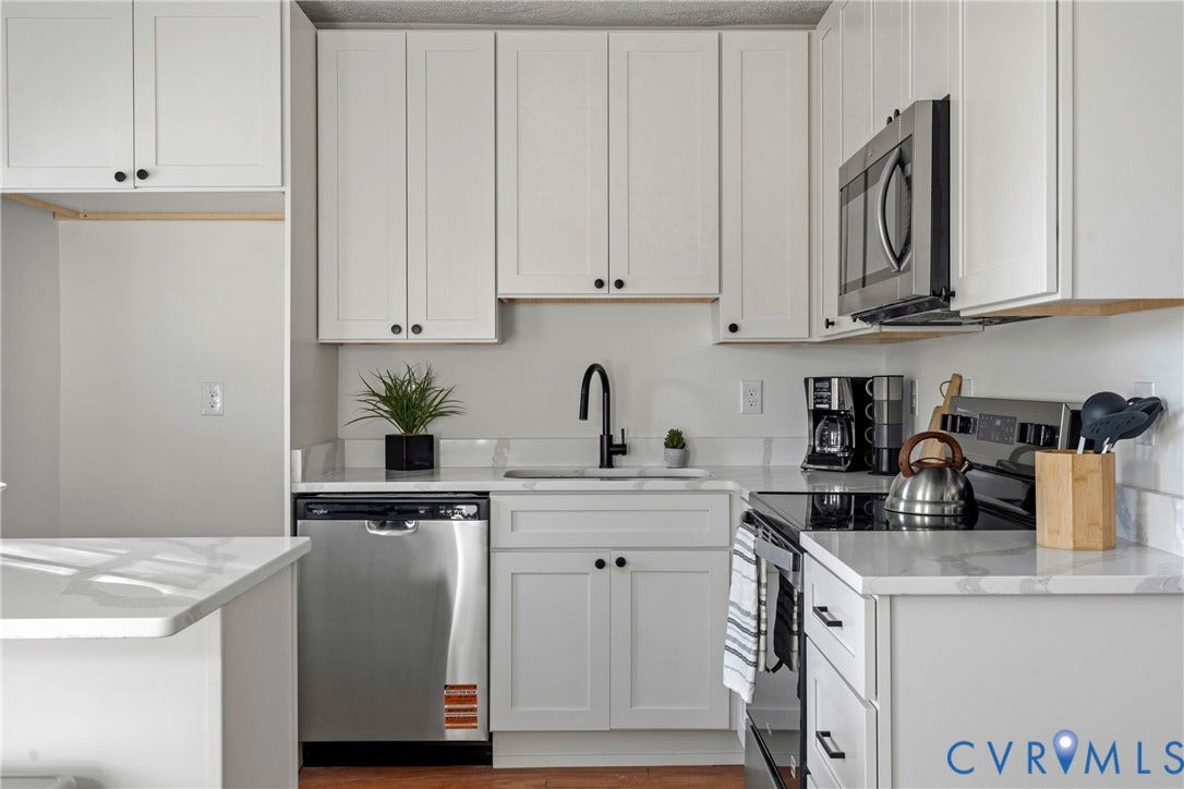 2931 W Leigh Street, Scotts Addition, Richmond, VA 23230 White shaker-style cabinetry, stainless steel dishwasher, stainless steel microwave, black matte faucet, and light-toned countertops