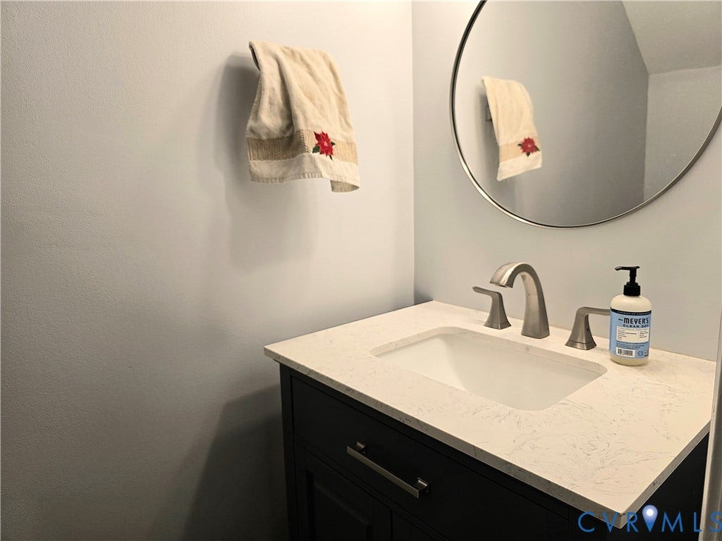 4207 Brixton Road, Creekwood, Chesterfield, VA 23832 Dark wood-finish vanity with an integrated rectangular sink, light stone-finish countertop, and brushed nickel faucet