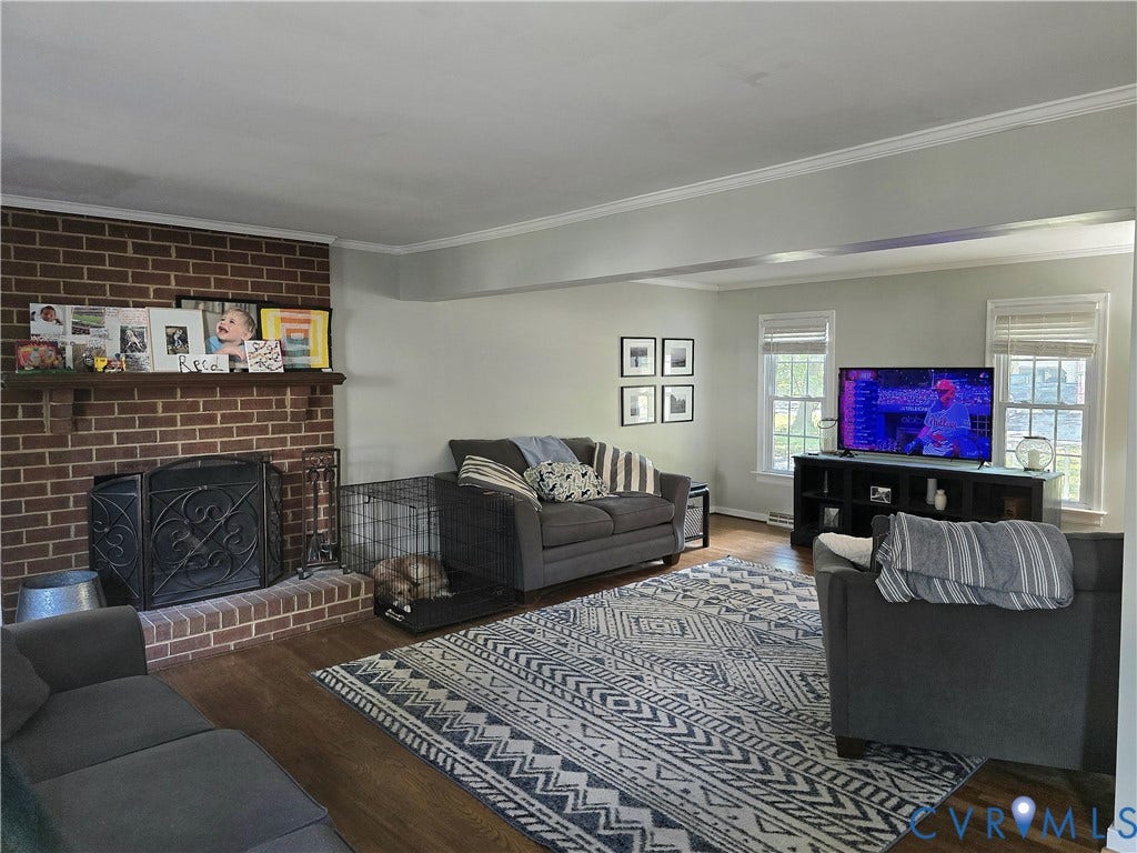 4207 Brixton Road, Creekwood, Chesterfield, VA 23832 Brick fireplace with a wood mantle, wood-finish flooring, white crown molding, and multiple windows