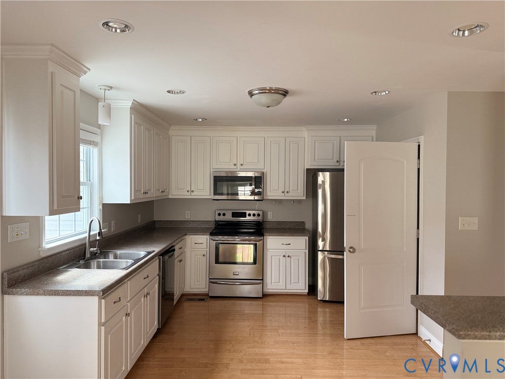 1709 Kemper Street, Richmond, VA 23220 White cabinetry with crown molding, stainless steel appliances, dual basin sink, wood-finish flooring, and recessed lighting