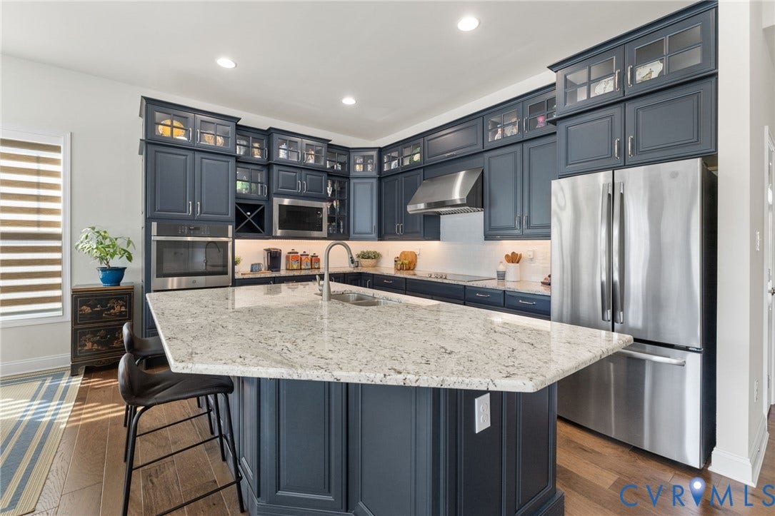 15750 Mosaic Creek Boulevard, Henrico, VA 23238 Kitchen featuring dark blue cabinetry, stainless steel appliances, a large island with a light-toned countertop, and wood-finish flooring