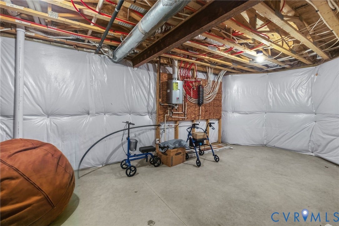 15750 Mosaic Creek Boulevard, Henrico, VA 23238 Unfinished basement with exposed ceiling joists, concrete flooring, insulated walls, and a tankless water heater installation