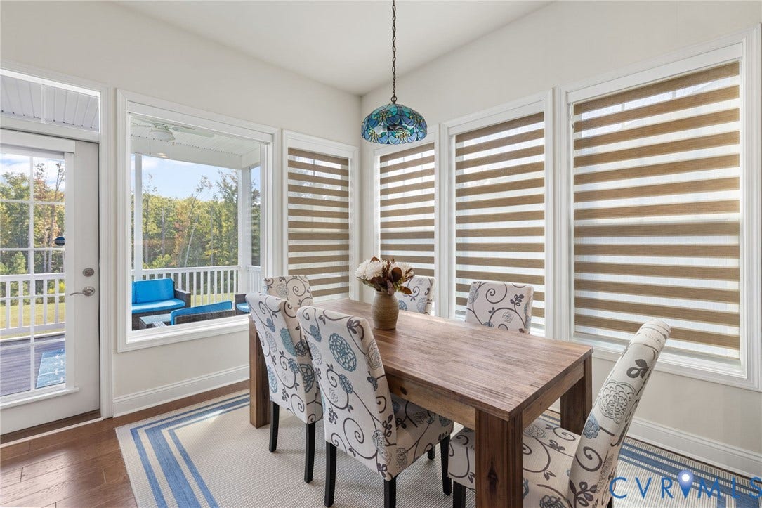 15750 Mosaic Creek Boulevard, Henrico, VA 23238 Dining area looking out onto the screened porch and back yard. A Tiffany-style pendant light fixture