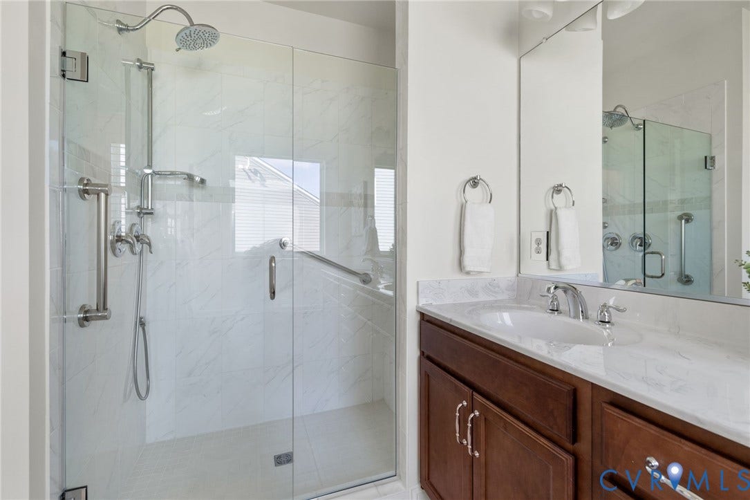 15750 Mosaic Creek Boulevard, Henrico, VA 23238 Walk-in shower with zero frame glass enclosure and rainfall shower head, grab bars and a bench