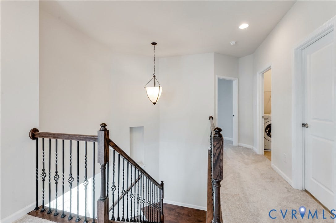 Staircase with dark wood handrail and decorative iron balusters