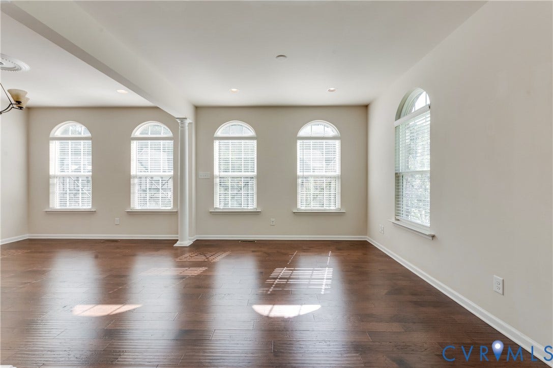 Hardwood-finish flooring, recessed lighting, and multiple arched windows with blinds
