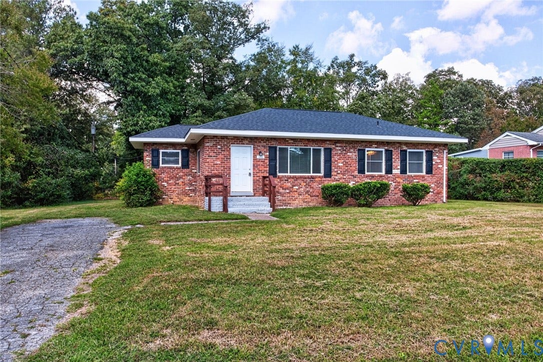 1118 Andros Road, Richmond, VA 23225 Brick exterior with dark roof shingles, white entry door, and black window shutters