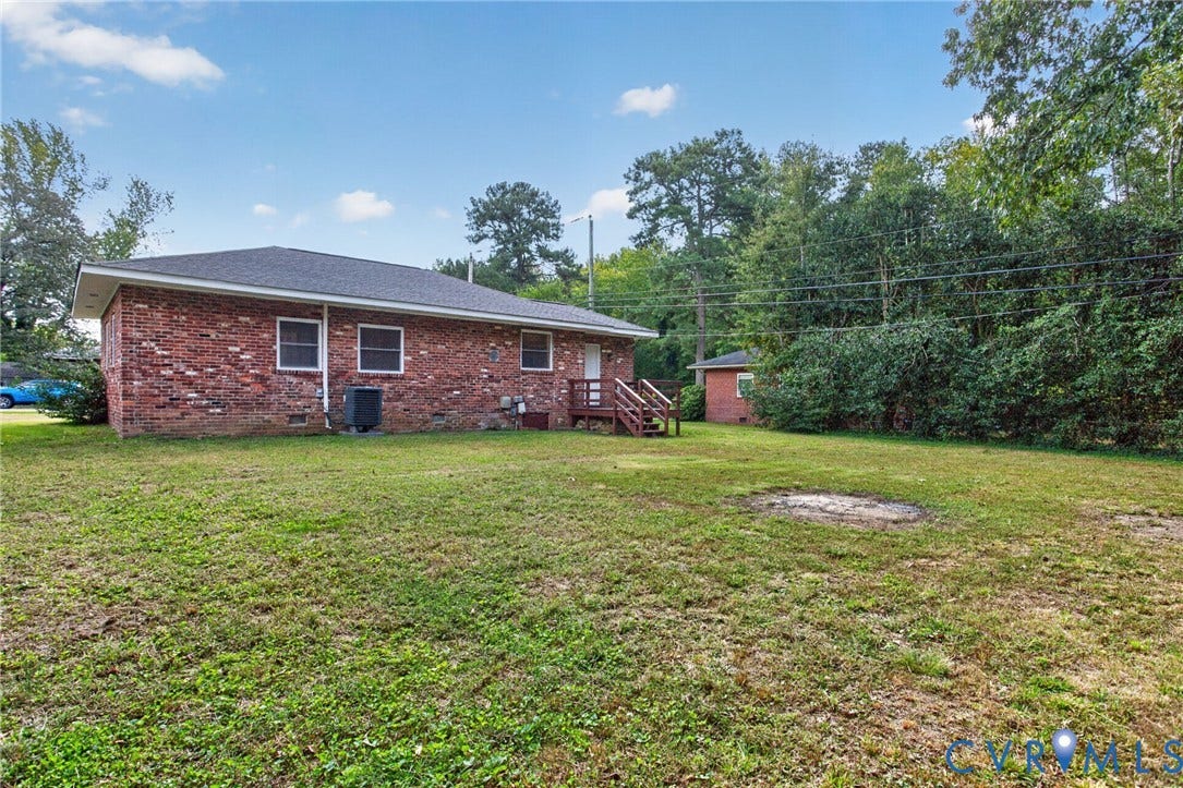 1118 Andros Road, Richmond, VA 23225 Brick exterior with white-framed windows, a dark shingle roof, and a wood deck