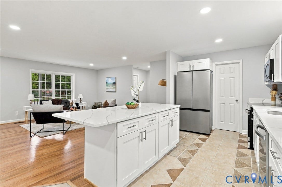 6409 Walmsley Boulevard, Chesterfield, VA 23224 Kitchen featuring an oversized central island with white cabinetry and stone-surface countertop, stainless steel appliances, recessed ceiling lighting, and wood-finish flooring