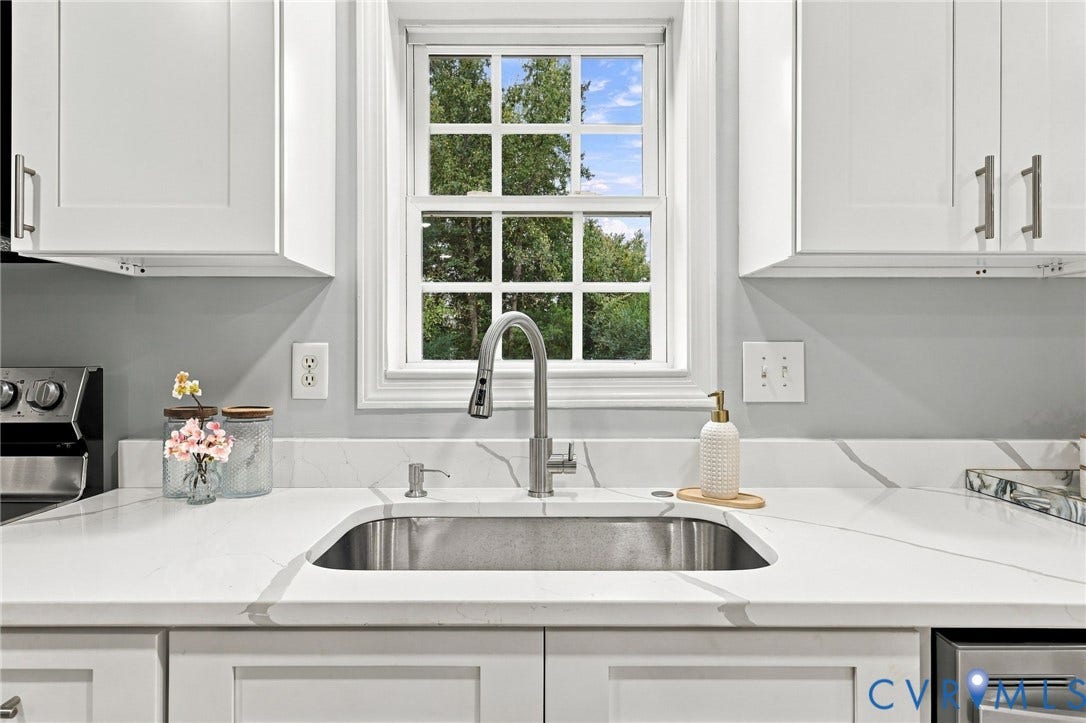 6409 Walmsley Boulevard, Chesterfield, VA 23224 Kitchen area featuring white shaker-style cabinetry, quartz countertops with gray veining, an undermount stainless steel sink, a pull-down stainless steel faucet, and a multi-pane window