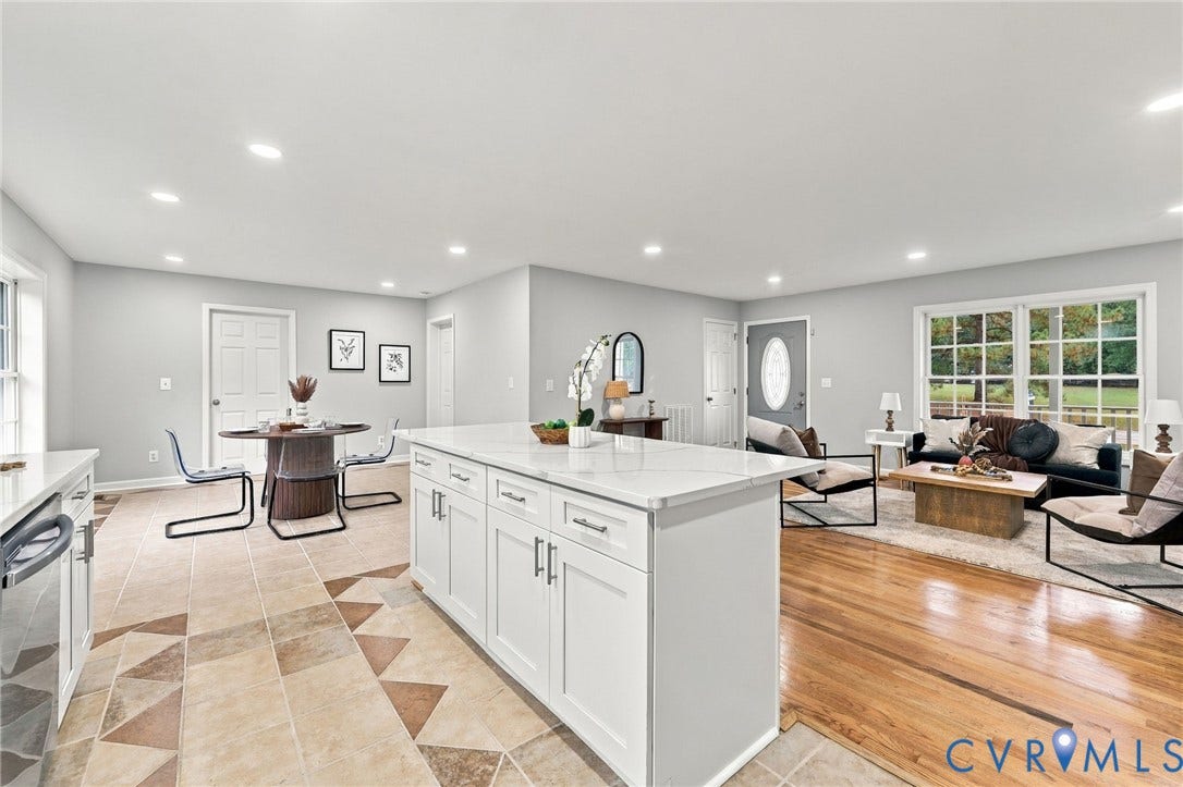6409 Walmsley Boulevard, Chesterfield, VA 23224 Open-concept interior featuring white cabinetry with stone-finish countertops, a central kitchen island, wood-finish flooring, multi-pane windows, and recessed lighting