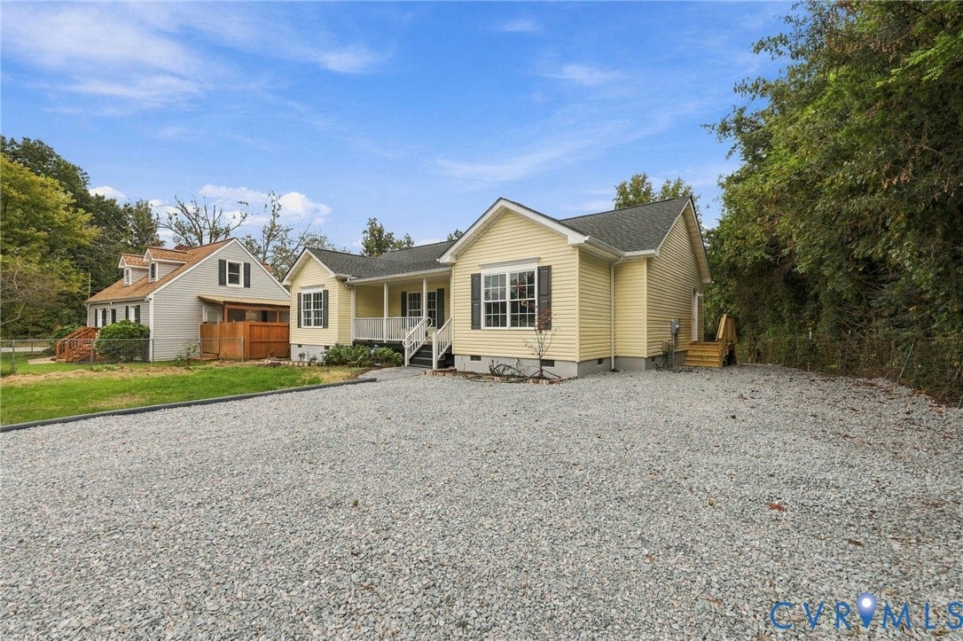 6409 Walmsley Boulevard, Chesterfield, VA 23224 Single-story residence featuring light-colored horizontal lap siding, a front covered porch with railings, and a gravel driveway