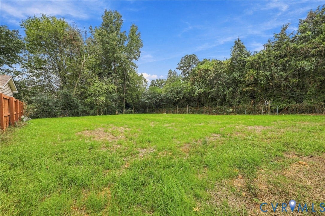 6409 Walmsley Boulevard, Chesterfield, VA 23224 Expansive grassy lot featuring a wood fence and perimeter of mature trees