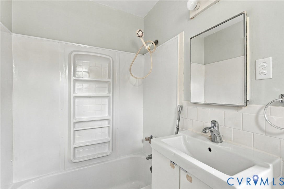 Full bathroom featuring a tub/shower combination, white vanity with integrated sink, and an integrated medicine cabinet