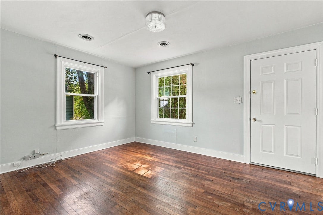 Hardwood flooring, two windows, recessed lighting, and a paneled door