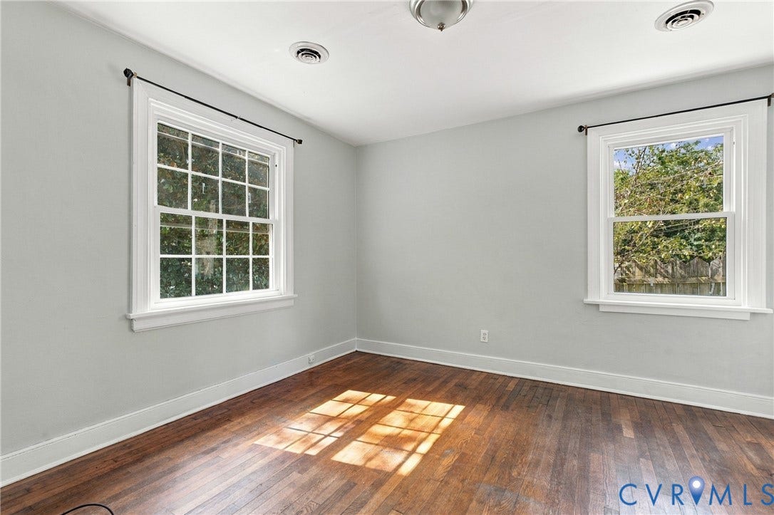 Wood-finish flooring, white trim, recessed lighting, and dual windows