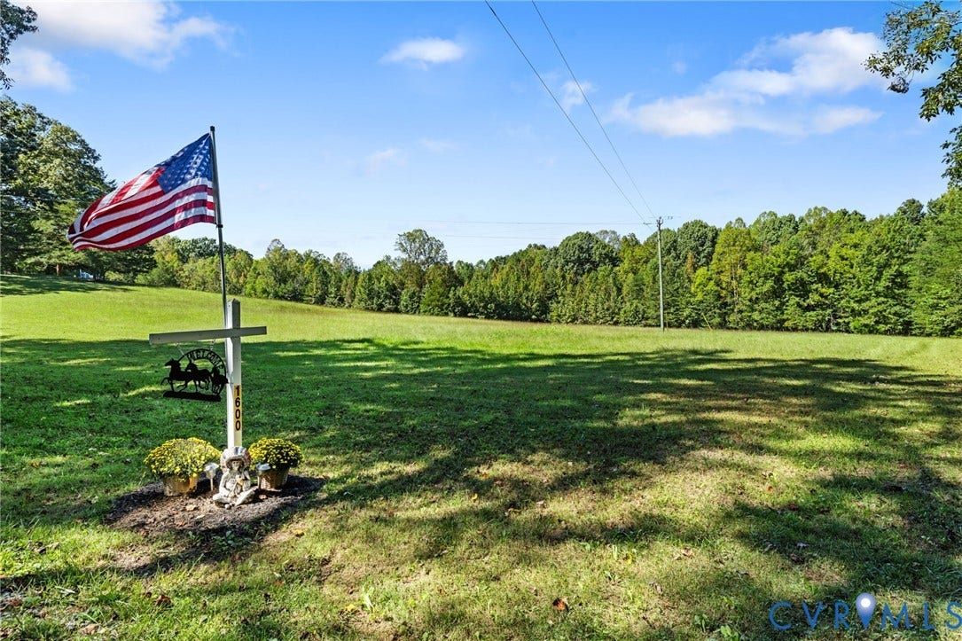 Expansive green space with distant mature tree lines and clear skies.