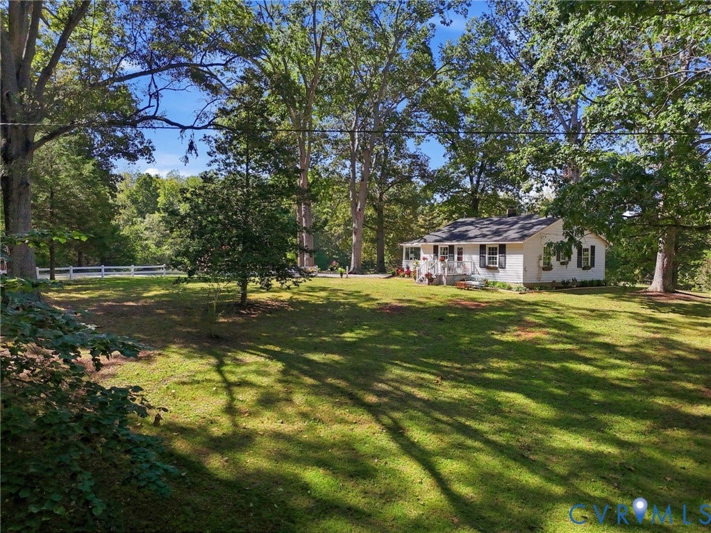 White exterior with black shutters and a covered porch.