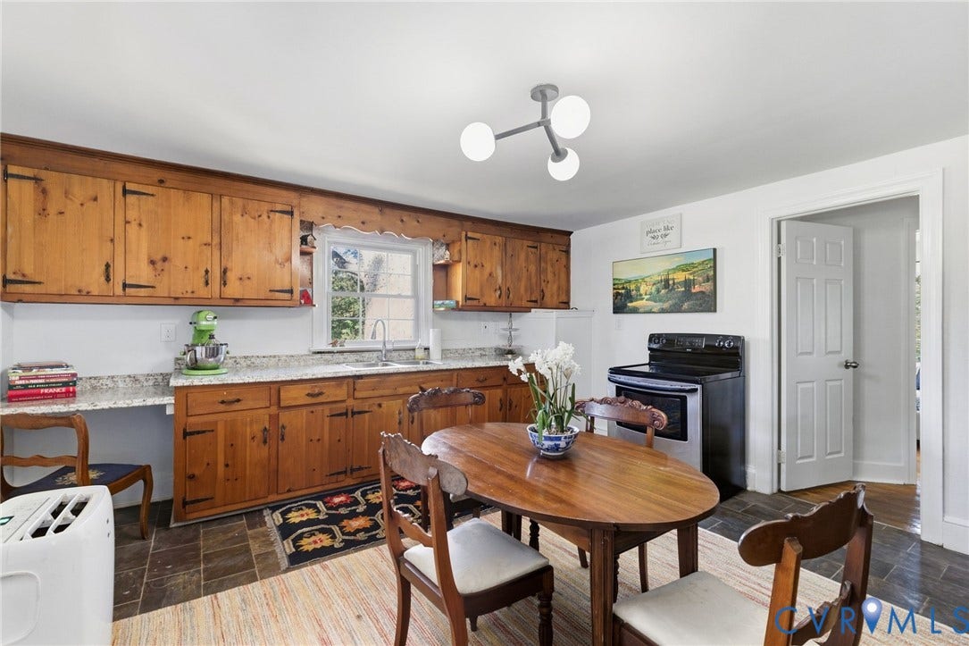 Wood-finish cabinetry, granite-style countertops, stainless steel sink, built-in oven with cooktop, and neutral flooring.