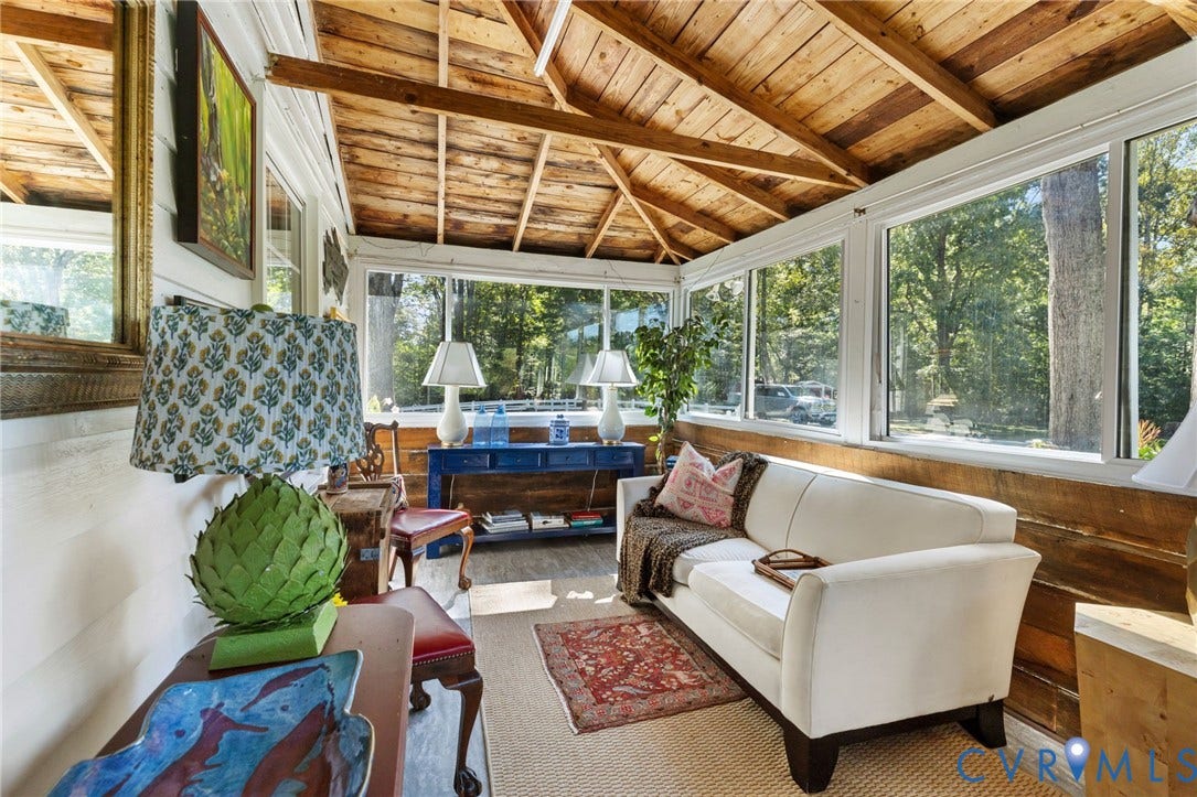 Sunroom featuring a natural wood ceiling, wood-finish walls, and extensive window-line.