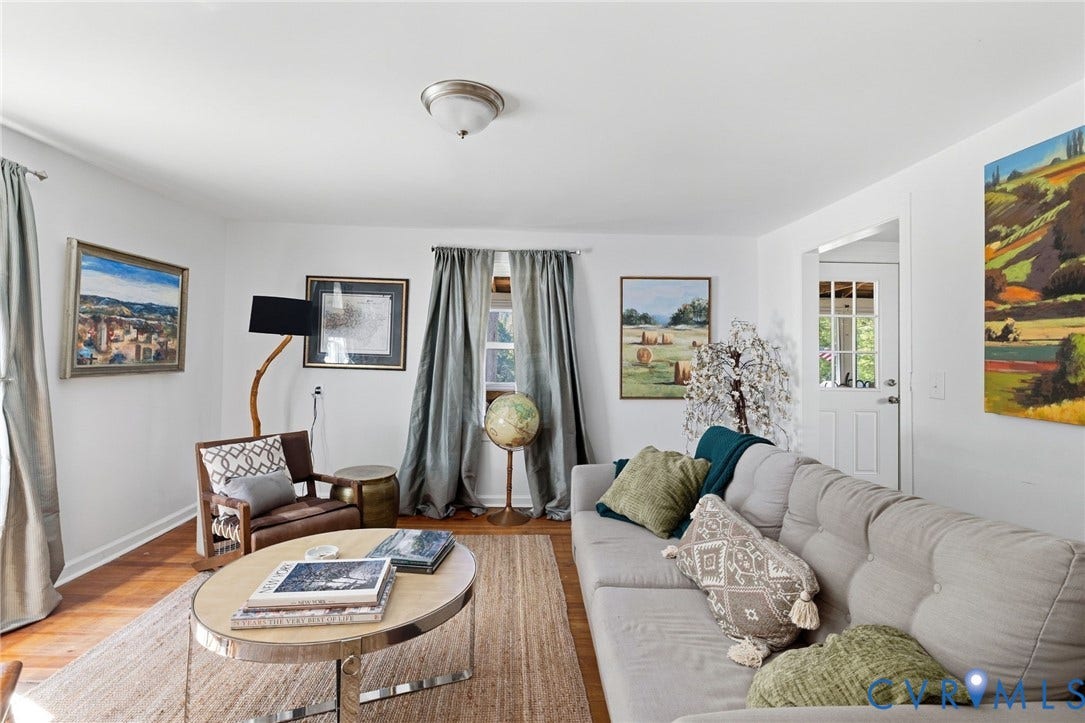 Wood-finish flooring throughout, bright white walls, and a recessed panel interior door with glass inserts.