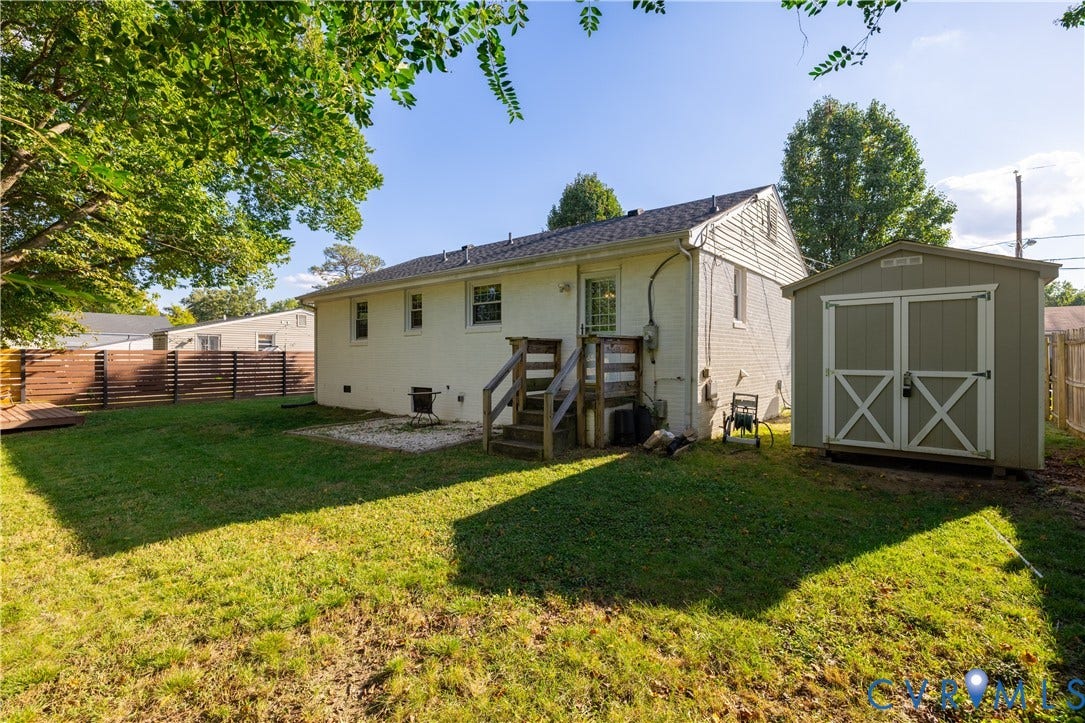 5312 Marian Street, Richmond, VA 23226 Expansive rear yard featuring a wood privacy fence, a detached storage shed, and a private wooden deck with stairs