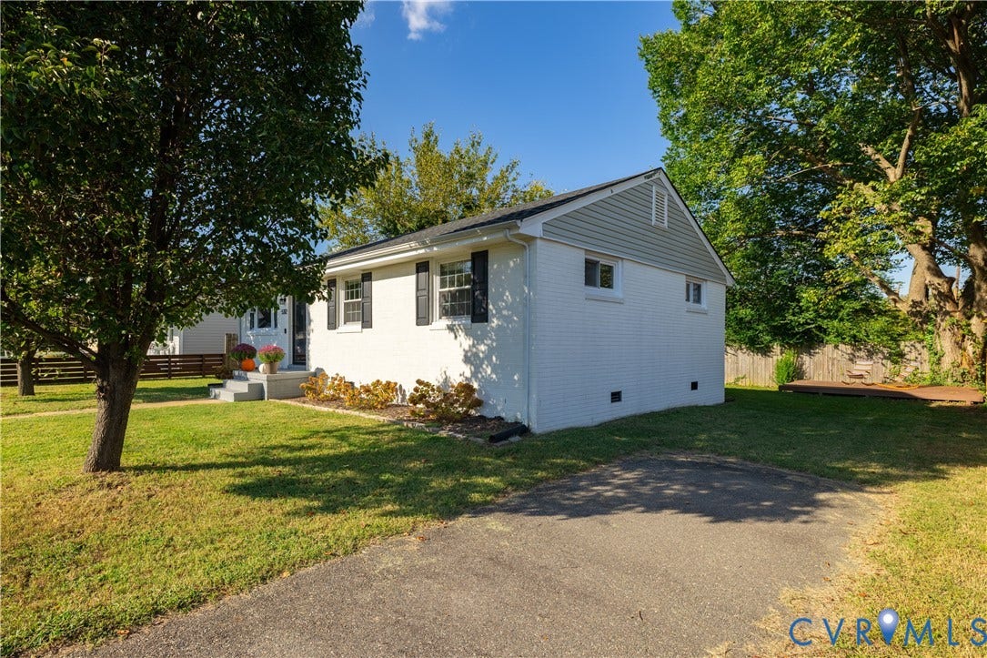 5312 Marian Street, Richmond, VA 23226 White brick exterior with black shutters, light gray siding, concrete porch, mature trees, and a wooden deck