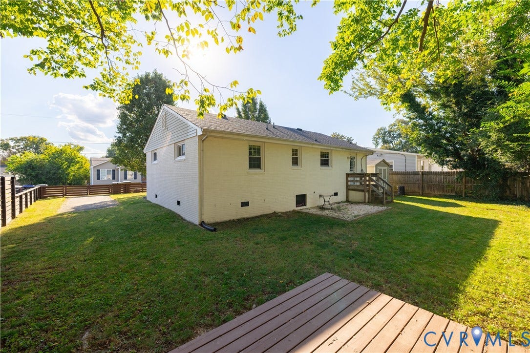 5312 Marian Street, Richmond, VA 23226 Expansive backyard with a manicured lawn, a raised wood deck, and a gravel patio area