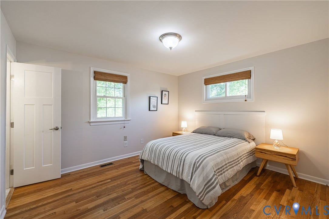 5312 Marian Street, Richmond, VA 23226 Hardwood flooring, two windows with natural woven shades, a paneled door, and overhead lighting