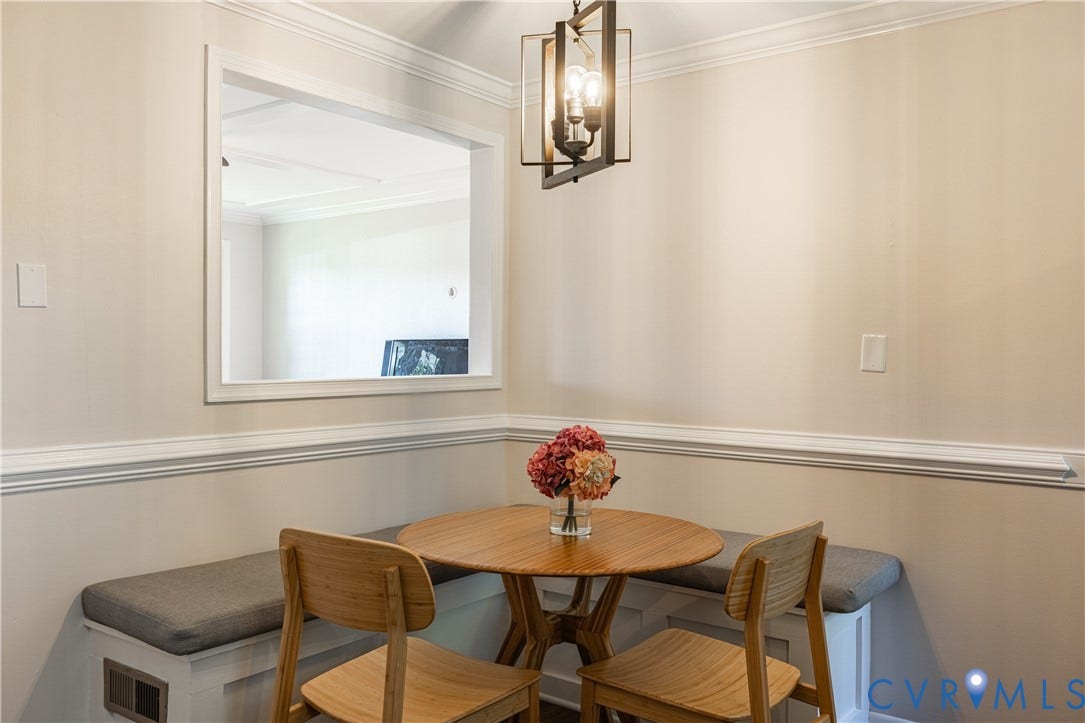 5312 Marian Street, Richmond, VA 23226 Built-in seating with cushions, pass-through window, crown molding, and a pendant light fixture