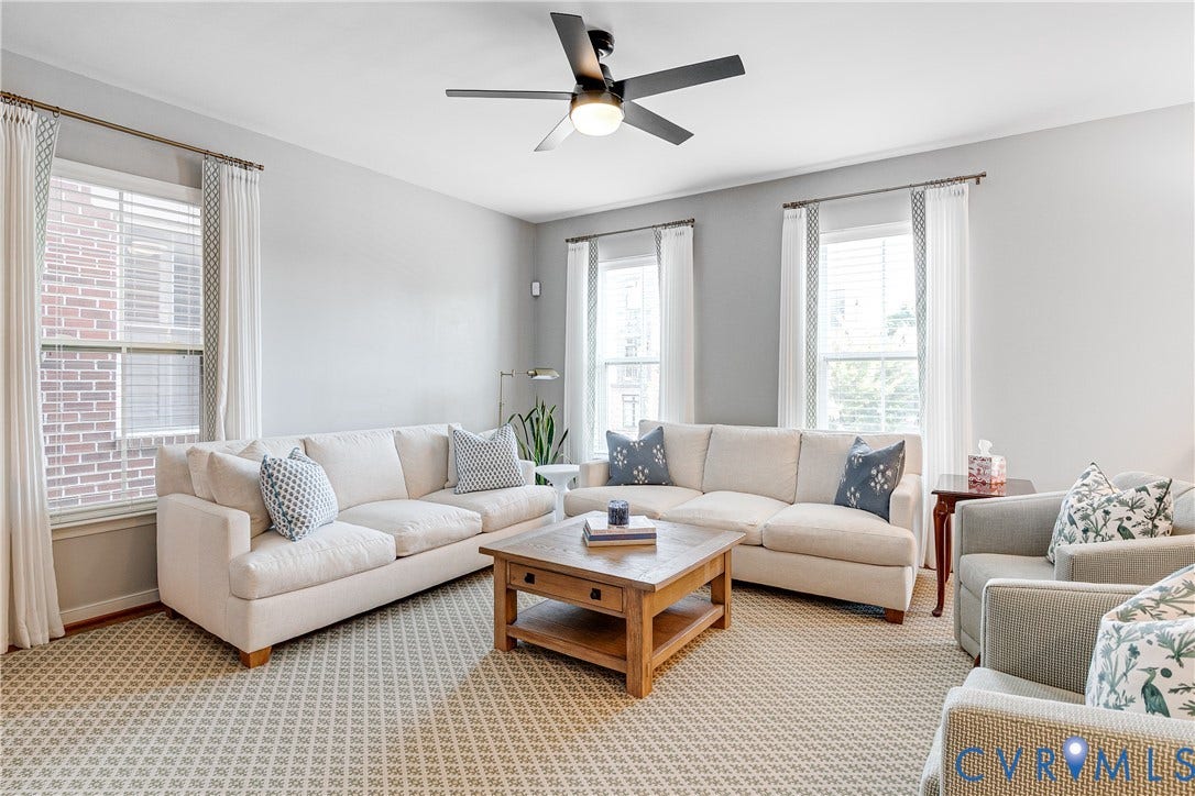 1733 W Cary Street, Richmond, VA 23220 Spacious room featuring multiple large windows, neutral wall tones, and a ceiling fan with integrated lighting