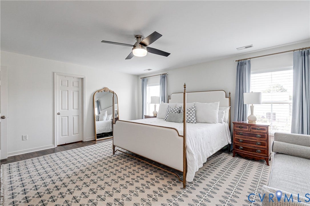 1733 W Cary Street, Richmond, VA 23220 Spacious primary bedroom with wood-finish flooring, white walls, and a ceiling fan with integrated lighting