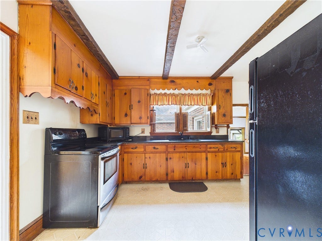Kitchen featuring wood cabinetry, exposed ceiling beams, and a built-in electric range