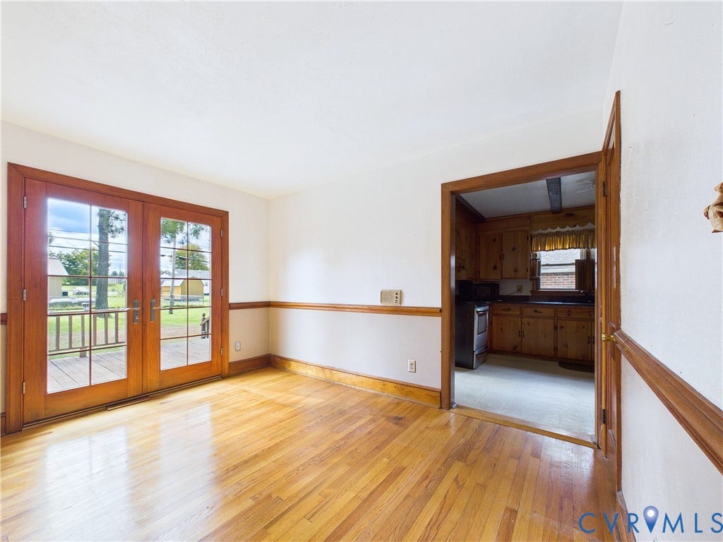 Hardwood flooring throughout, French doors with glass panels, wood trim, and chair rail molding