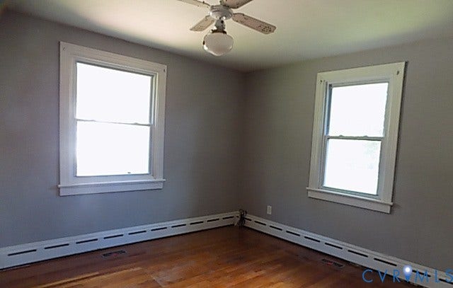 212 Royal Oak Avenue, Riverside Park, Colonial Heights, VA 23834 Hardwood flooring, two double-hung windows with white trim, a ceiling fan, and baseboard heating